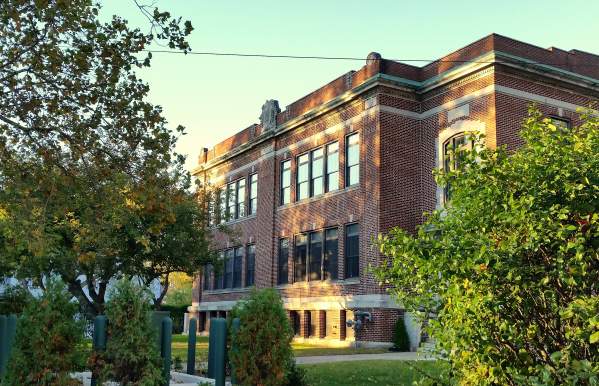 A brick building with trees in the foreground.