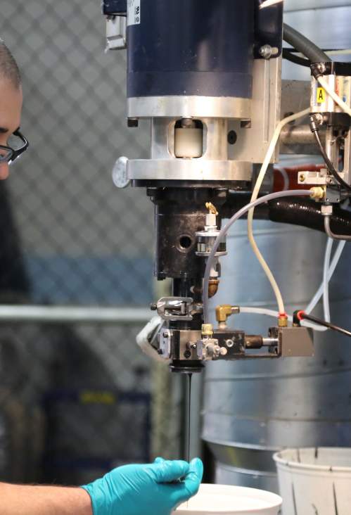 A man operating a machine inside a manufacturing facility.