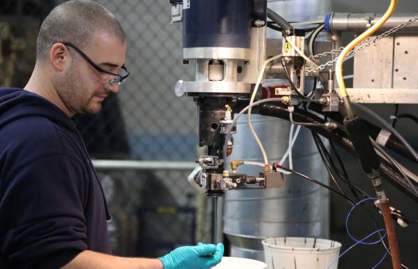 A man operating a machine inside a manufacturing facility.
